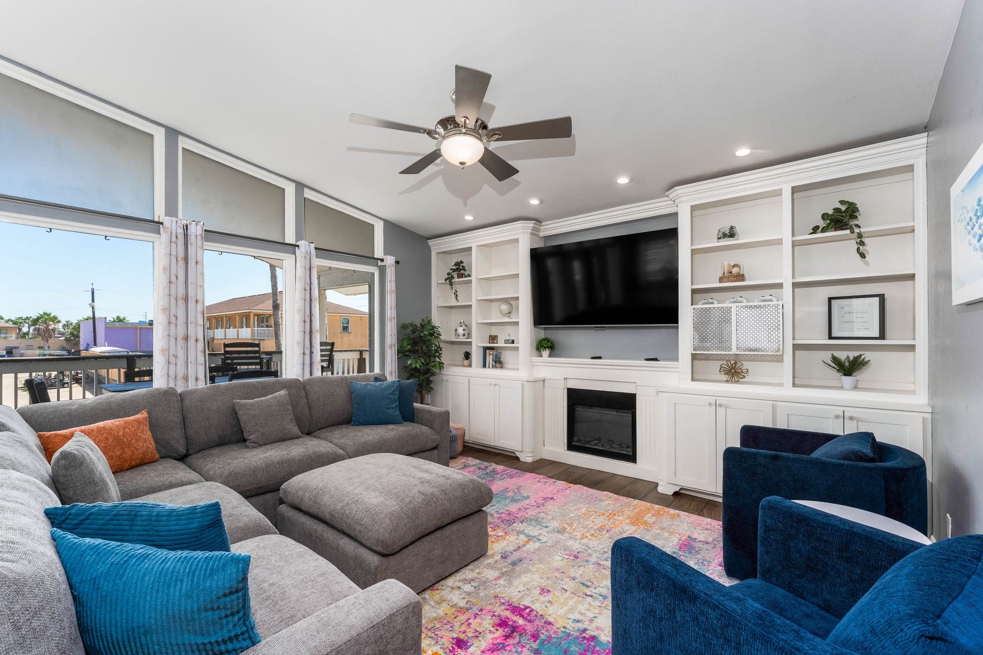 Living room with new sectional, fireplace, and balcony access